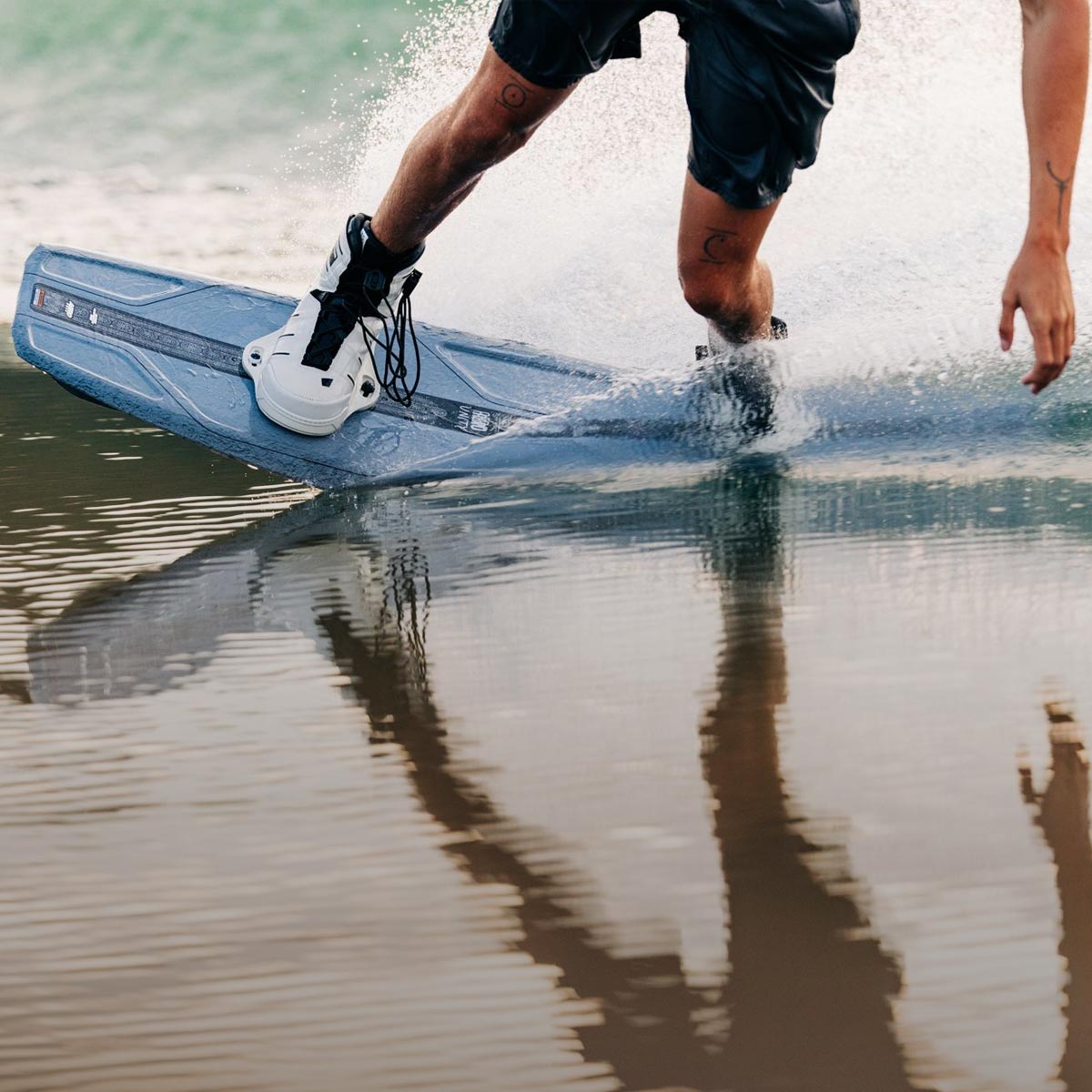 Liquid Force 6X Wakeboard Bindings Collection - Close up picture of LF Athlete Sam Brown riding his wakeboard on smooth water.